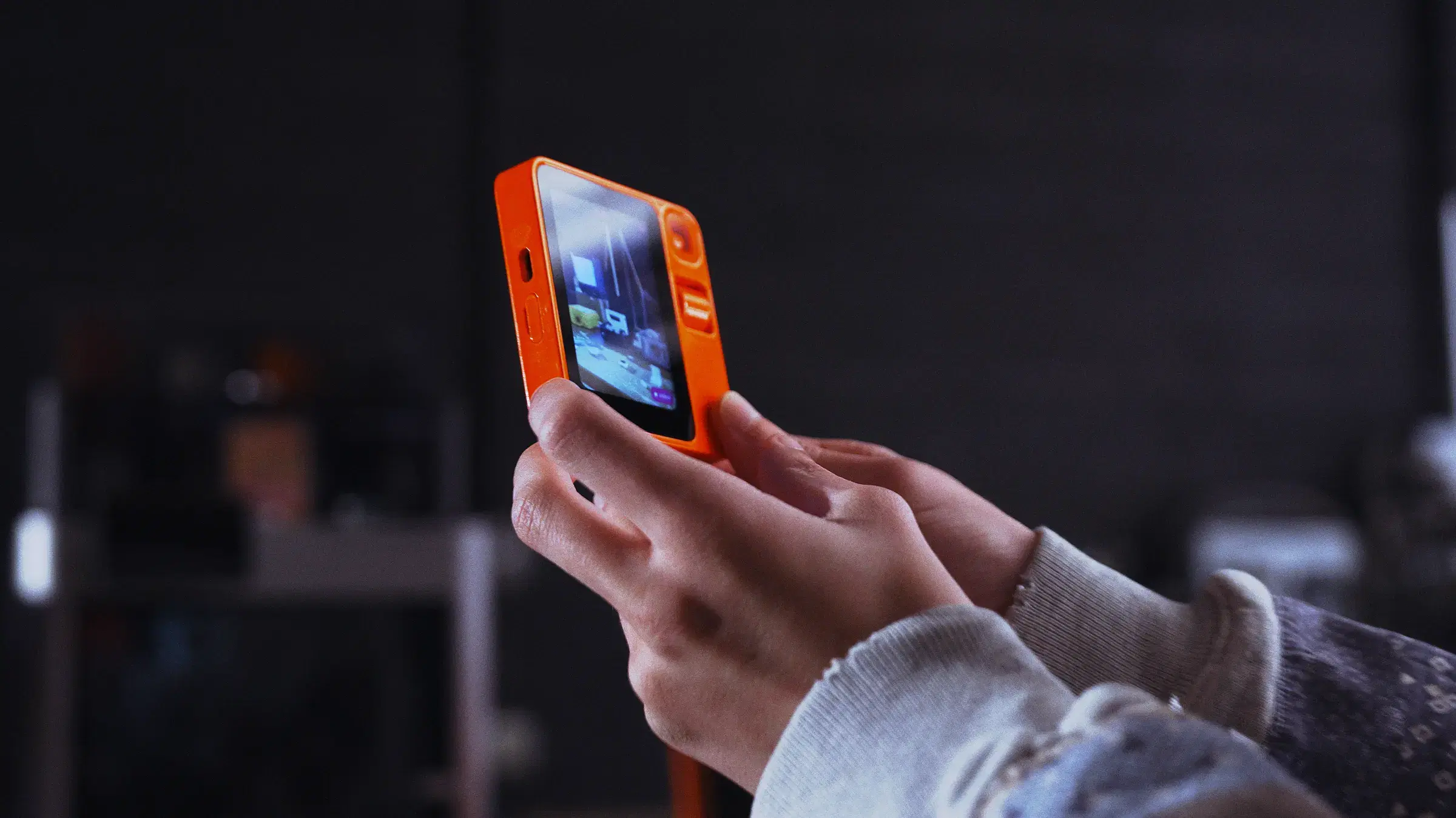 rabbit r1 held in one hand, running OS3